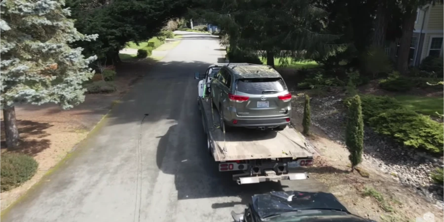 Tow truck picking up an SUV from a driveway in Moses Lake, WA